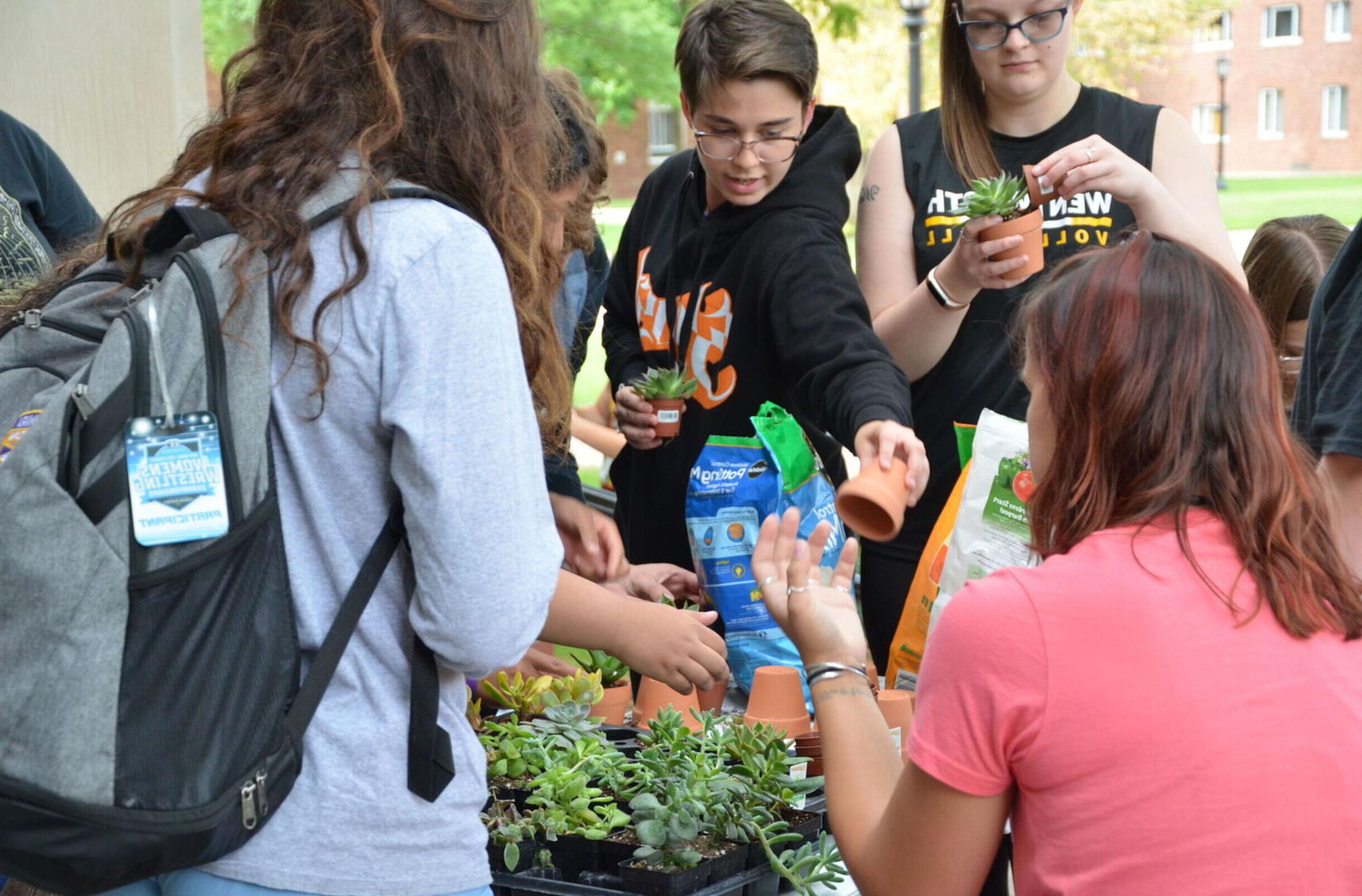 Students do a planting activity at the Environmental Club's table during the Club and Organizations Fair